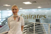 Dubai International Airport - Fiona Devlin, Cabin Crew Trainer, with Emirates training simulator in the background.