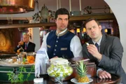 Kommissar König (Mark-Alexander Solf, r.) glaubt, dass Barkeeper Martin Lindner (Moritz Tittel, l.) den Cocktail vergiftet hat, um Plessen zu beseitigen.