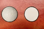 Ein Golfball mit Dellen und ein Ball ohne Dellen
