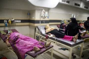 Pakistanische Verwandte neigen zu Hitzschlagopfern, als sie in einem staatlichen Krankenhaus in Karatschi, Pakistan, behandelt werden.