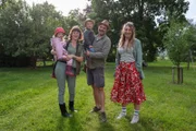 Familie Wieland erzieht ihre Kinder bedürfnisorientiert, liebevoll und mit vielen Freiheiten. Im Bild: Mutter (l.) und Vater Wieland (M.) mit je einem Kind auf dem Arm mit Jasmina Neudecker (r.)