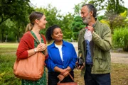 Elisabeth "Betty" Hertz (Henrike Hahn, l.) und Zoe Breitner (Catherine Chikosi, M.) treffen Safi Edemir (Ercan Durmaz, r.) im Park, der gerade für seine Kunden Sekt und Eiswürfel organisiert hat.