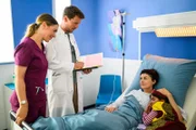 Elisabeth Hertz (Henrike Hahn, l.) und Dr. Julius Walden (Constantin Lücke, 2.v.l.) stehen am Krankenbett von Iris Herdinger (Liza Tzschirner, 2.v.r.), die von Ihrer Tochter Jonna Herdinger (Soraya Maria Efe, r.) besucht wird. Alle sind sehr erleichtert, dass die OP gut verlaufen ist.
