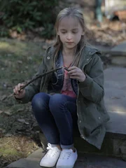 Child Robin playing by herself with a wooden stick.