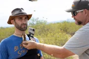 Chris begins putting bees onto the queens necklace around Coyote’s neck for his bee beard.