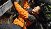 Bear Grylls holds onto wooden frame of mine.