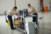 ATSB Investigator Simon Grummett (played by Justin Mader) tells another investigator to pack up damaged engine parts from Qantas Flight 32.