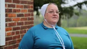 Mary standing near a house.