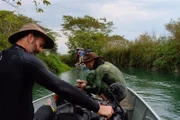 Mario and Coyote prepare their gear while going upriver on their boat.