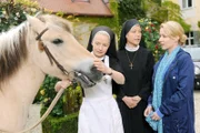 Frau Fassbender erzählt, dass sie sich das Pferd nicht mehr leisten kann. Schwester Agnes würde das Pferd gerne behalten (v.li.: Emanuela von Frankenberg, Janina Hartwig, Natalie O’Hara).