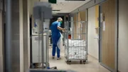 Krankenschwester schleppt den Wagen mit dem Bettzeug