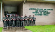 Vollzugsbeamte für Wildtiere und Fischerei in Louisiana vor einem Schulungskomplex.