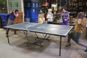 Leonard und Sheldon werden eingeladen, einen Vortrag an der UC Berkeley zu halten, während sich ein Garagenverkauf bei Bernadette (Melissa Rauch, M.), Howard (Simon Helberg, 2.v.r.), Amy (Mayim Bialik, r.), Penny (Kaley Cuoco, 2.v.l.) und Raj (Kunal Nayyar, l.) zu einem Tischtennis-Turnier entwickelt ...