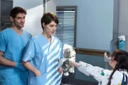 Marlene Krahmer (Holly Williams, r.) macht Dr. Koshka (Katharina Nesytowa, M.) ein Geschenk, weil sie ihre Mama geheilt hat. Theresa und Dr. Ahrend (Roy Peter Link, l.) sind gerührt.
