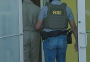 Ein HSI-Agent eskortiert einen Gefangenen in ein Gebäude in Fajardo, P.R.