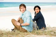 Darra (Julian Cullen links) und Kyra (Kimie Tsukakoshi rechts) haben ein magisches Portal passiert und sind an einem unbekannten Strand gelandet. Doch nun ist das Portal verschwunden und ihnen der Rückweg versperrt.