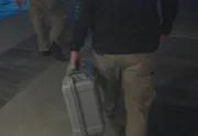 Zwei CBP-Agenten gehen an einem Bootssteg am Meer entlang, wobei ein Agent eine Pelikan-Aktentasche in St. Thomas, USVI, in der Hand hält.