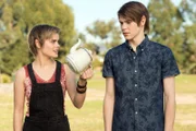 Imogen (Elizabeth Cullen links) zeigt ihrem Bruder Darra (Julian Cullen rechts) eine Teekanne. Damit will sie einen magischen Stuhl einfangen, der unkontrolliert durch den Park fliegt. Darra ist misstrauisch, ob das klappen wird.