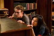 Kyra (Kimie Tukakoshi, rechts) hat Peter (Jamie Carter, links) heimlich mit in die Bibliothek genommen. Als sie Geräusche hören, verstecken sie sich. Sie wollen nicht entdeckt werden.