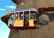 Die Zoobande hat es geschafft: Endlich liegt der Felsbrocken nicht mehr auf den Schienen sondern auf den Gabelstaplern der Bahn. Balduin, der Bär, und Zacki haben die Bahn in ein "Helimobil" verwandelt und bringen den Brocken zusammen mit ihren Freunden weg.