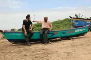 RJ and Captain Fulbaria sit on a boat talking. A retired sea captain, Captain Fulbaria is now found in the Diu Seashell Museum where he painstakingly collects and presents thousands of seashells from around the world.