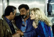 Die schöne Nina (Shannon Tweed, r.) und Howard (Roy Thinnes, l.), ein Gaunerpärchen, wollen Mark (Victor French, M.) helfen, seinen Reichtum gewinnbringend anzulegen.