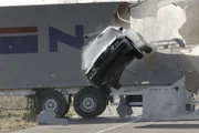 Die Gangster fliehen vor den Kommissaren und crashen durch einen querstehenden LKW...