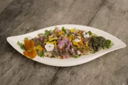 Bei Andrea Meßmer, Jachenau, Oberbayern. Gruß aus der Küche: Knödel-Carpaccio mit Hackfleisch vom Yak auf einem Rucola-Bett und Gundermann-Walnuss Pesto.