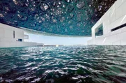 Ins Wasser gebaut und nach drei Seiten geöffnet: Die Kuppel über dem Louvre Abu Dhabi spendet Licht und Schatten.