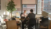 Der Mann sitzt da und hört seinem Gesprächspartner zu