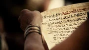Eine Person hält einen Papyrus
