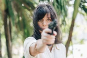 Eve (Marianne Denicourt) fühlt sich bedroht und zeigt den anderen Hotelgästen, dass sie eine Waffe besitzt und sich zu wehren weiß.