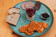 Bei Rahel Kremershof, Wipperfürth, Bergisches Land. Gruß aus der Küche: Bergische Kaffeetafel mit Waffeln, Milchreis mit Kirschen, Holzofenbrot, Leberwurst, Rindsalami, Zuckerrübensirup.