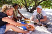 Reiseleiter Bernd und Anja essen mit Guide Heiaril am Strand von Huahine (Französisch-Polynesien).