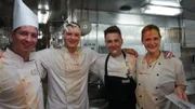 Sous-Chef Pascal Pichler, Gast-Koch Carsten, Sous-Chef Philipp Schonder und Patisserie-Praktikantin Agnes bei ihrer Verabschiedung. Küchenchef Christian und seine Crew haben eine andere Art sich zu verabschieden. Denn nach altem Küchenbrauch muss Agnes noch gebührend verabschiedet werden. Die Küchencrew freut sich, Agnes weiß noch nicht so recht, wie ihr geschieht. Das ändert sich schnell, als Sous-Chef Philipp mit einer ganz besonderen Torte ankommt und Agnes ins Gesicht drückt.