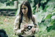 Die junge Botanikerin Nina (Matilda Lutz) schaut sich auf der Insel um und macht Fotoaufnahmen.