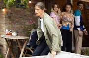Katrin Hübner (Alexandra Gottschlich, v. mit Komparserie) kommt von einer Dienstreise zurück und erfährt vom Tod ihres Sohnes.