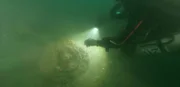 Ein Taucher erkundet ein Wrack auf dem Meeresgrund