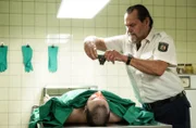 Jäger (Markus John) ist in der Mittagspause bei Dr. Reitzig, er erkennt den Toten und macht ein Foto.