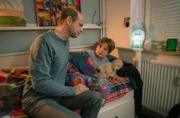 Stefan Trautmann (Benjamin Morik, l.) ist alleinerziehend und gesundheitlich angeschlagen. Die Situation mit seinem Sohn Benji (Henry Sendzik, r.) überfordert ihn.