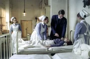 Ein weiterer Fall von Diphtherie: Student Georg Tischendorf (Maximilian Meyer-Bretschneider, 2.v.r.) soll dem kleinen Patienten einen Luftröhrenschnitt verpassen. Hilfswärterin Ida (Alicia von Rittberg, l.) und Wärterin Edith (Tanja Schleiff, 2.v.l.) können nur hoffen, dass er das beherrscht.