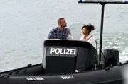 Michael Jungbluth (Florian Schmidtke, l.) hat das WaPo- Boot gekapert, weil er seiner Geliebten Zola Burchardt (Sithembile Menck, r.) helfen will. Diese steht unter dem Verdacht ihren Mann ermordet zu haben.