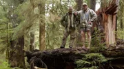 USA, Washington, Olympic National Forest, Cody Lundin and Dave Canterbury standing atop fallen log in Pacific Northwest rainforest during Dual Survivor filming