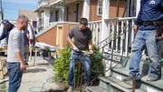 Before shot of Keith Bynum and Evan Thomas working on the bent front porch railing at the Creole Cottage house, as seen on Bargain Block New Orleans, Season 1.