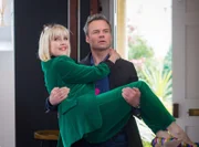 James Lacey (Jamie Glover) gratuliert Agatha Raisin (Ashley Jensen) zu ihrer bestandenen Prüfung als Privatdetektivin.