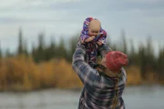 Ashley lifting baby Sydney into the air.