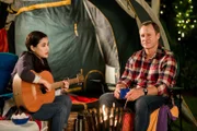 Kyra (Kimie Tsukakoshi, links) und ihr Vater Steve (Steve Nation, rechts) zelten in ihrem Vorgarten, nachdem es mit einem größeren Camping-Ausflug nicht geklappt hat.