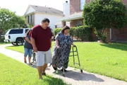 Olivia, her brother and her sister in law walking down the sidewalk.