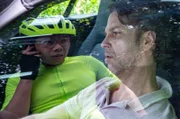 Thomas Brandner (Yung Ngo, l.) radelt durch den Wald bis er nach einer Kurve fast gegen ein Auto fährt. Er will die Person (Ingmar Grapenbrade, r.) im Auto zur Rede stellen, doch die ist tot.
