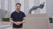 Mirko Drotschmann vor dem Friedenssymbol "Non Violence" von Carl Fredrik Reuterswärd auf dem UN-Gelände in New York.